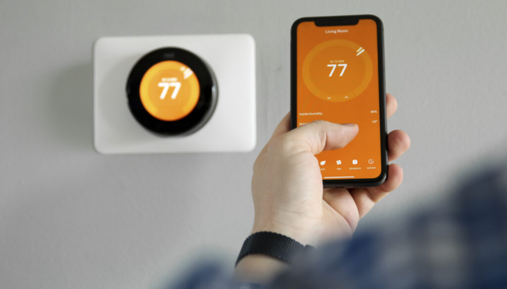 Man uses a mobile phone with smart home app in modern living room